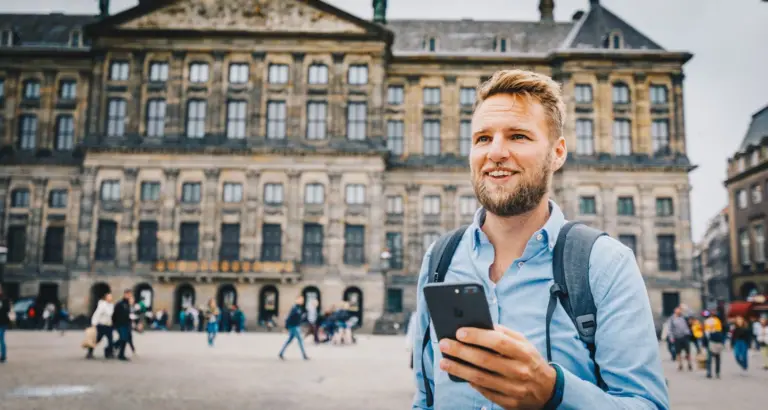 Ein Mann steht auf einem Stadtplatz und nutzt Voys VoIP auf seinem Handy mit einer österreichischen 0720-Nummer ohne geografische Bindung.