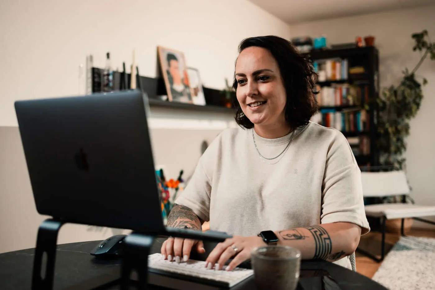 Maya zit thuis aan een bureau te typen op haar toetsenbord.