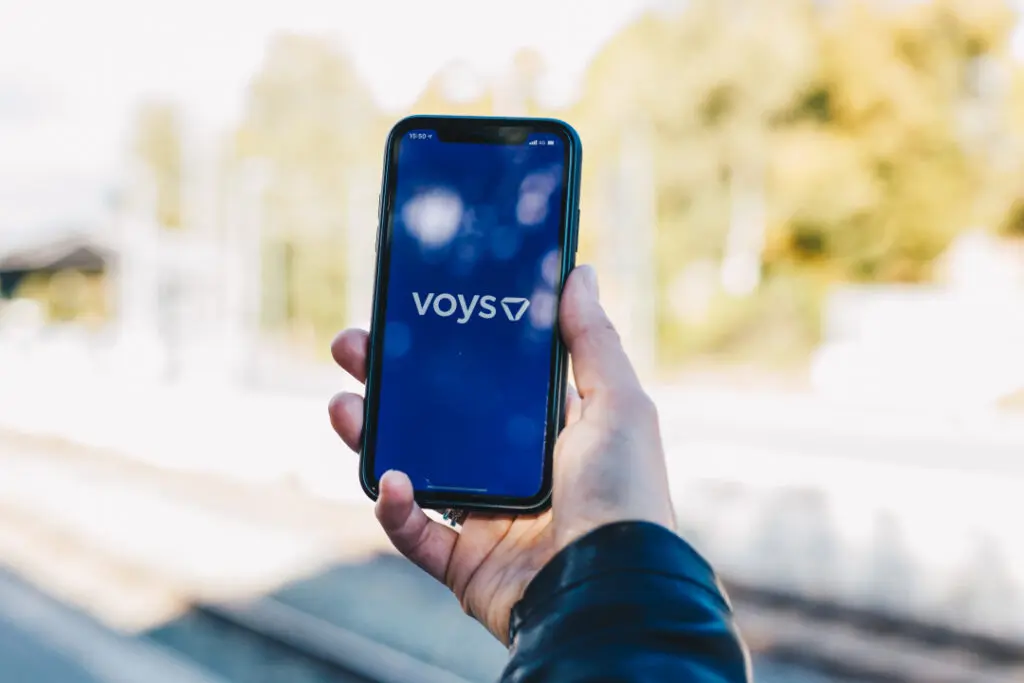 A man holding a cell phone using the voys app