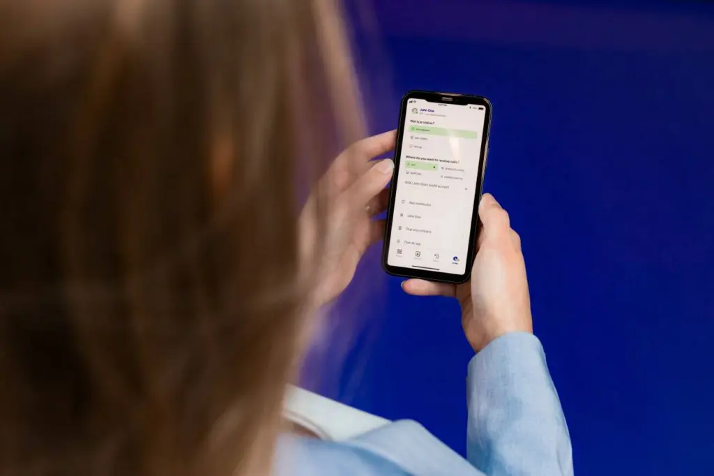 Voys app on screen with lady holding mobile phone
