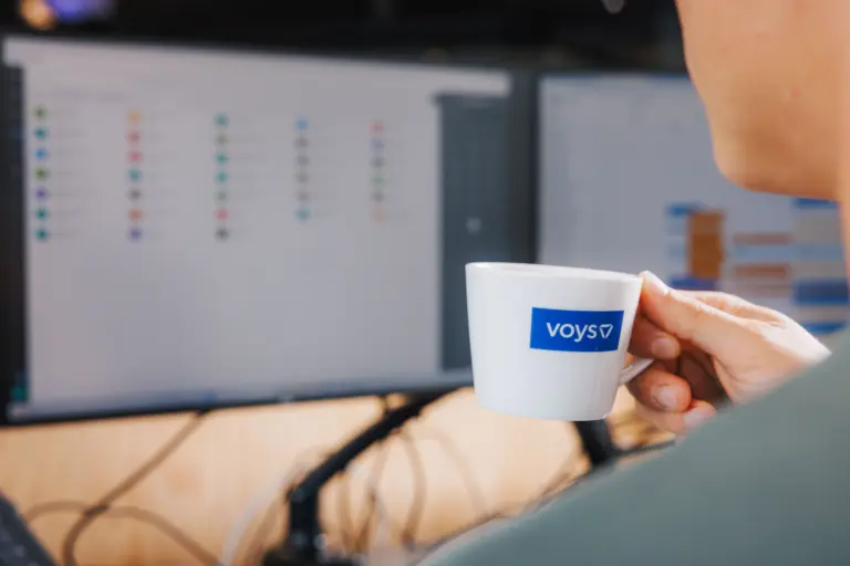 Voys Colleague Holding Voys mug and working in the Cape Town Office of Voys